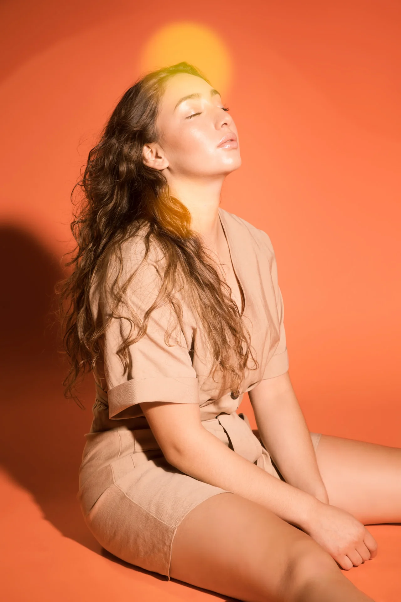 Retrato con fondo naranja y el pelo al viento