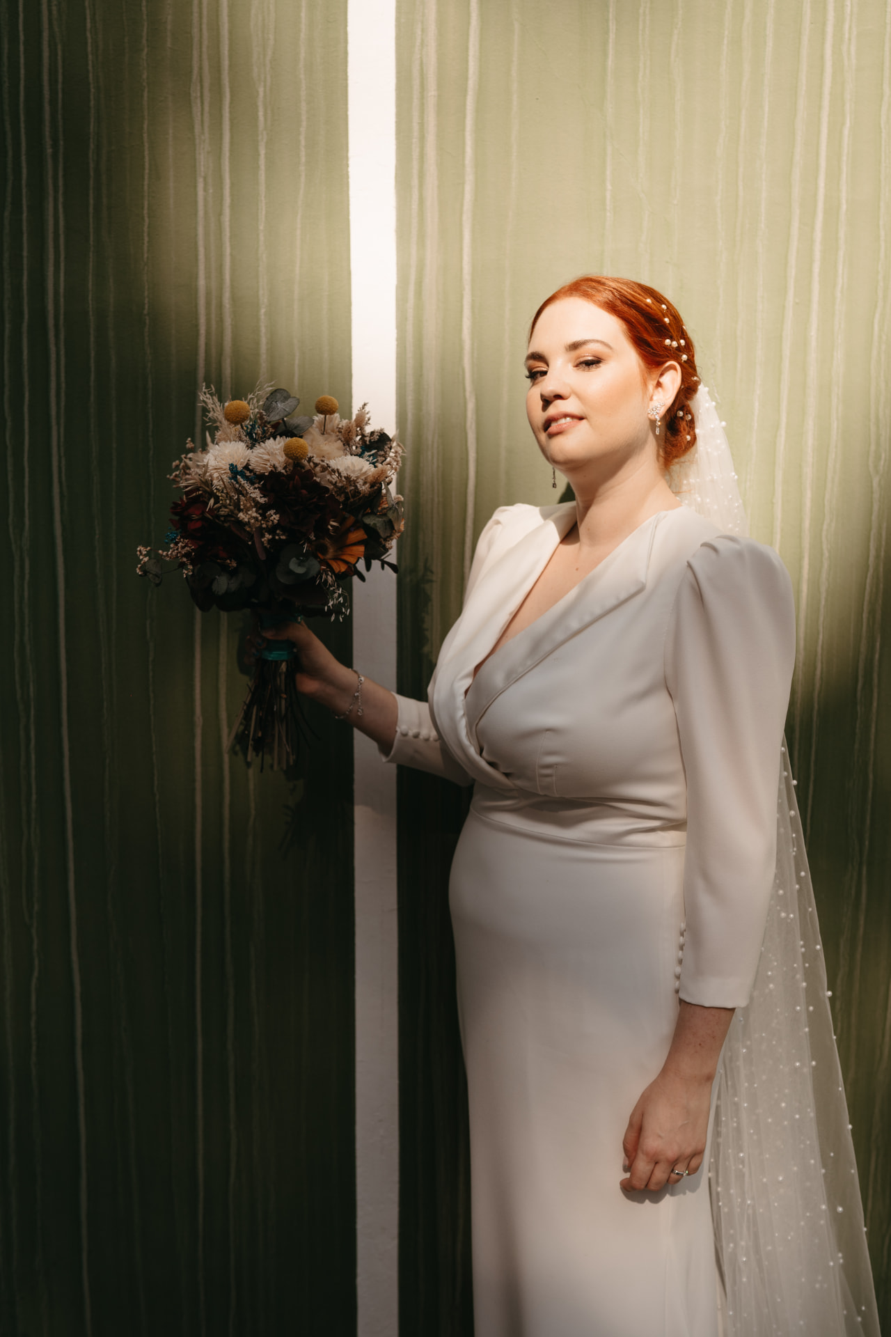 Novia pelirroja con maquillaje luminoso y peinado recogido